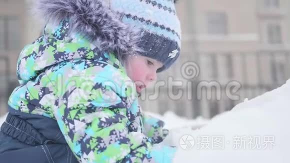 一个小孩子在雪山上玩耍。 晴朗的霜天。 新鲜空气中的乐趣和游戏。