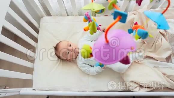 顶部的照片，可爱的婴儿与其他躺在婴儿床和看旋转移动