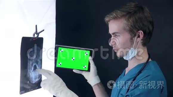 男性医生检查x光图像，使用绿色屏幕片。