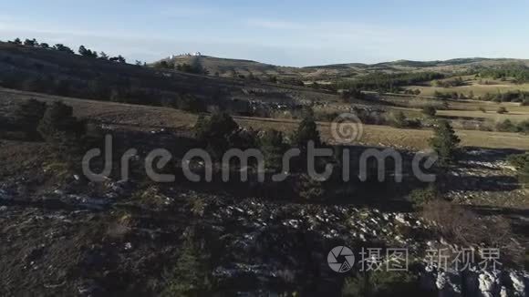 从丘陵山谷的土地全景。 中。 石山的俯视和蓝天的地平线。 白色天文台