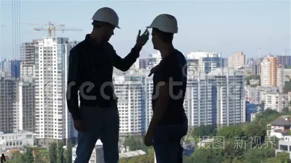 两个建筑工人看高楼的景观视频
