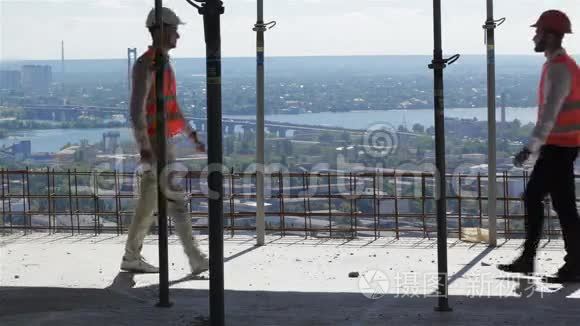 两位建筑工人从正在施工的建筑物中观察河流景观