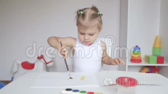 坐在桌子旁的小可爱女孩在相册里画画