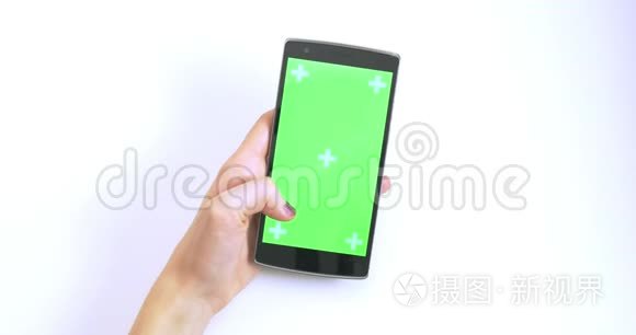 女子手摇在绿色屏幕智能手机与跟踪者白色背景