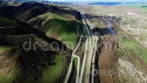 一条河附近的公路和美丽的绿色田野和山丘的史诗般的镜头