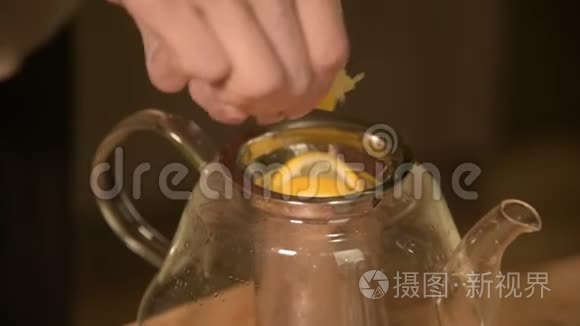 女性手的特写是用柠檬把一把刀切成碎片，挤在木桌上泡茶