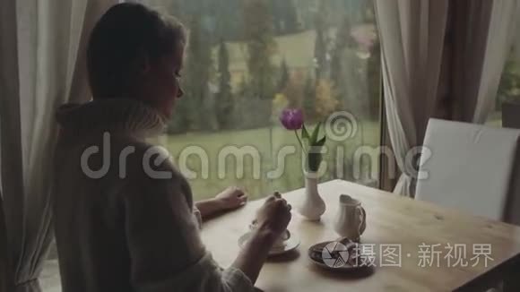 有咖啡的女人在等朋友。 漂亮的年轻孤独的女人坐在咖啡馆或家里喝杯咖啡。