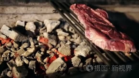 新鲜的肉片在烤架上炸视频