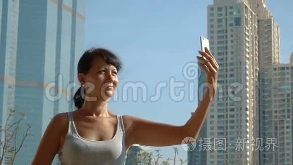 微笑的女人在摩天大楼的背景下自拍