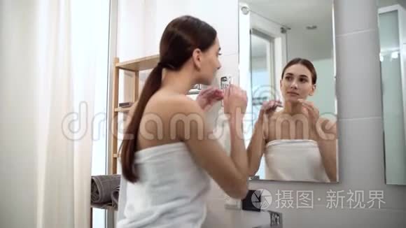 皮肤护理。 女人摸脸看镜子看浴室