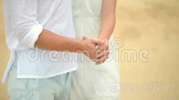 在热带海滩穿白色衣服的夫妇。