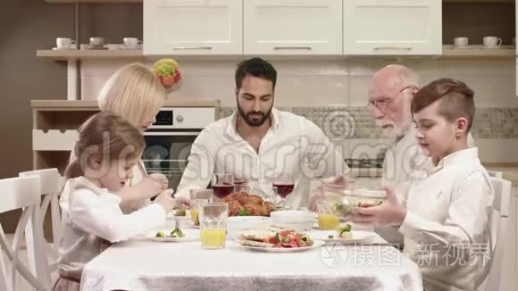 全家人围坐在餐桌旁，吃饭交流和享受家庭晚餐。
