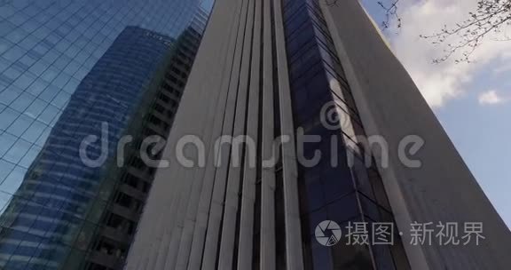 从下往上靠近树的现代玻璃建筑