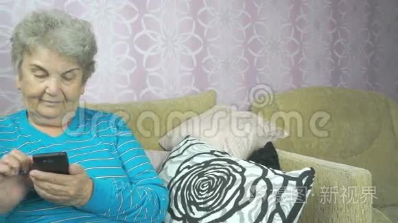 使用手机的老年妇女坐在沙发上视频