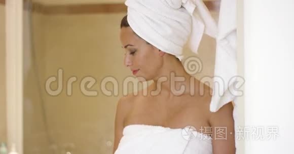 站在浴室摊上裹着毛巾的女人