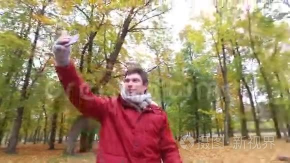 有智能手机的人在秋公园拍视频视频