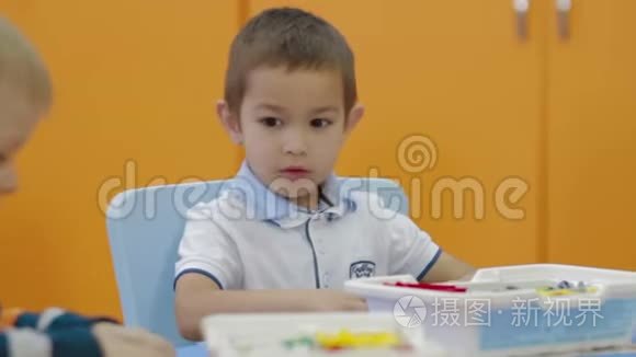 在幼儿园玩塑料积木的男孩视频