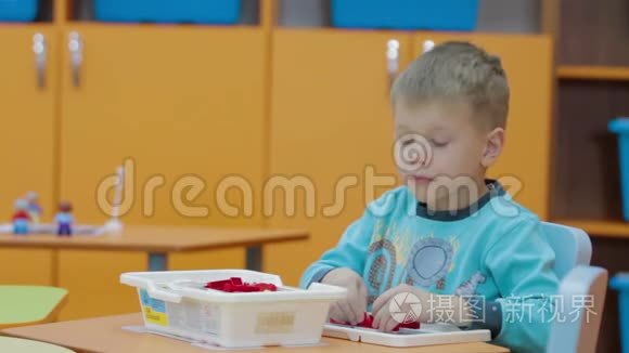 在幼儿园玩塑料积木的男孩