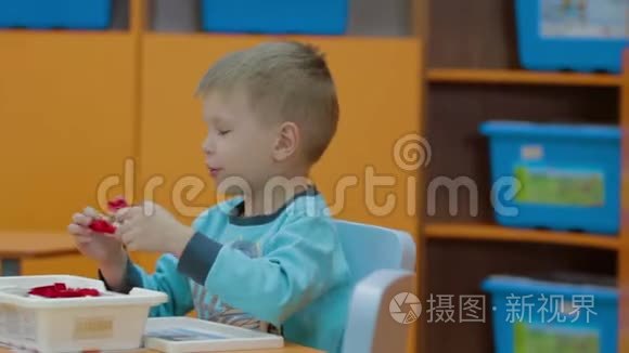 在幼儿园玩塑料积木的男孩