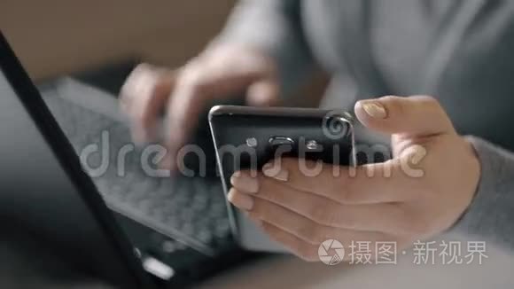 一个女人用笔记本电脑和智能手机工作