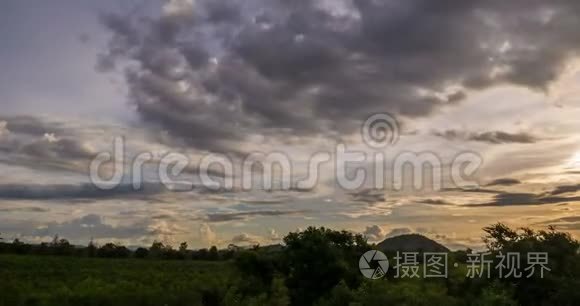 在黄昏时分，天空在树和山的上空五彩斑斓