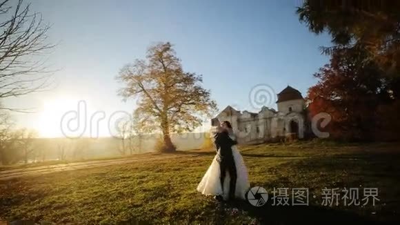 已婚夫妇在日落时跳舞。 新郎举起