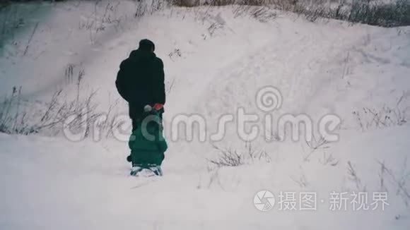 男人拉着一个女儿在冬天的森林里雪橇