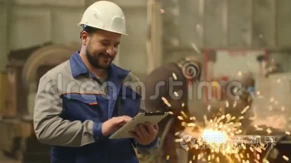 在重工业工厂里，工程师看着摄像机微笑着举起大拇指