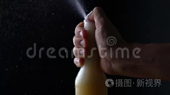 一瓶啤酒在黑色背景下的喷泉。 慢速视频