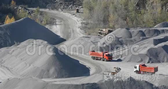 自卸卡车在花岗岩采石场行驶，在采石场用重型机械开采石块