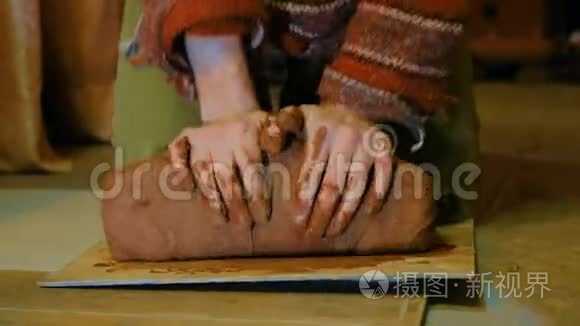 职业男陶工在陶器作坊里揉泥巴视频