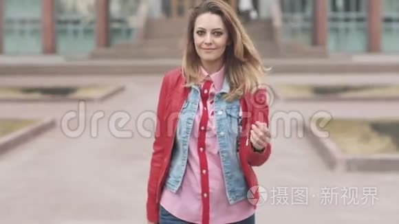 一个年轻迷人的女人的肖像。 美丽的金发女孩看着相机微笑。 头发的风