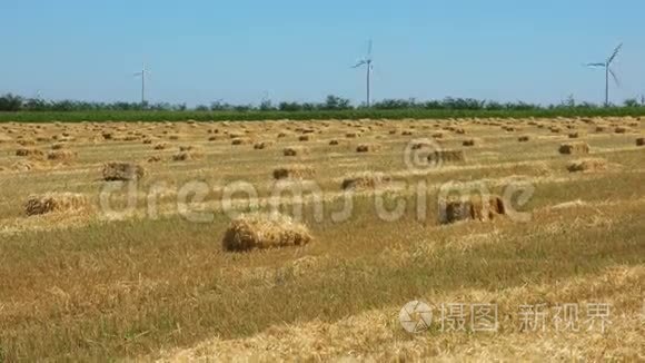 用风力涡轮机在农田上铺设草捆视频