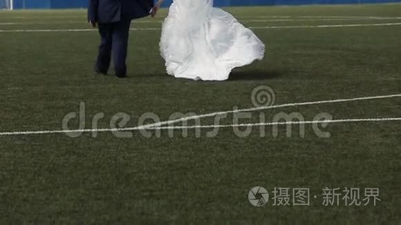 新婚夫妇在足球场上散步