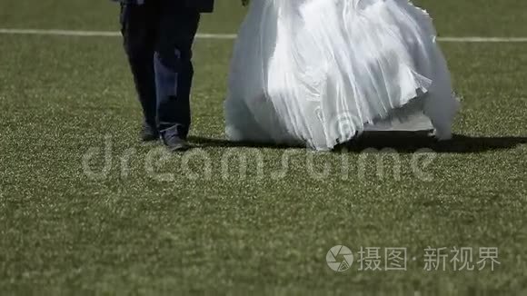 新婚夫妇在足球场上散步