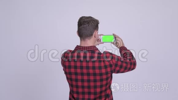 时髦男人用电话拍照的后景视频