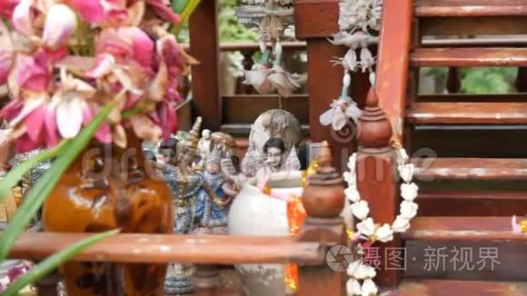 泰国花园中装饰精美的传统佛教祭坛，有鲜花和各种象征人物