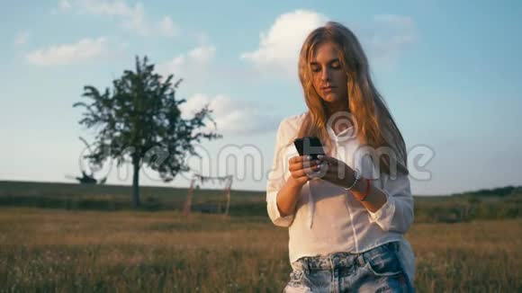 夏天公园里的女人用手机。 真实的创意镜头视频的预览图