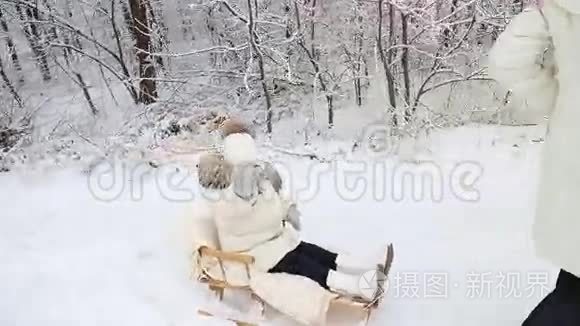 妈妈婴儿在雪橇上翻滚