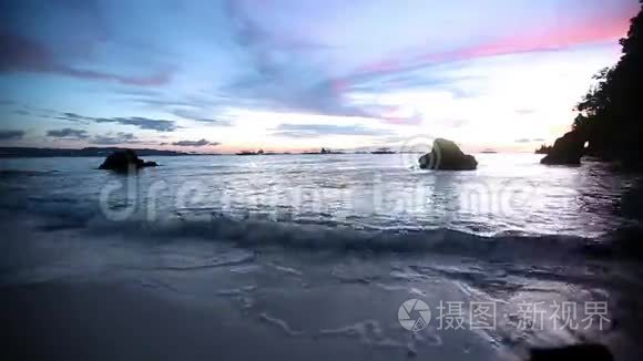 海滩上的日落-宁静的田园诗般的景色，金色的日落在海面上，海浪慢慢地溅在沙滩上