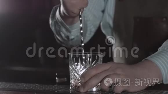 酒保正在搅拌混合杯里的鸡尾酒，现代酒吧