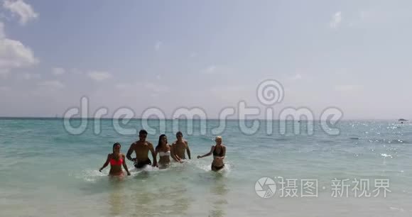 沙滩上的水上奔跑的人们，夏日快乐的男女游客