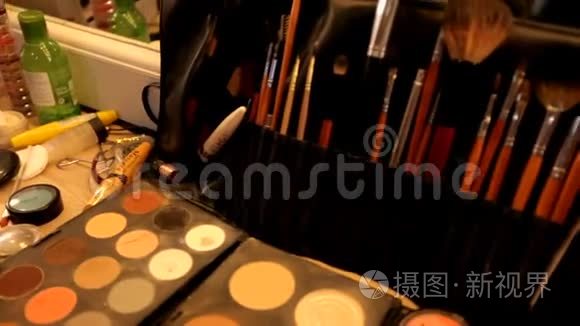 专业的化妆品化妆师在工作室的桌子上。 五彩的口红，阴影，化妆的基础..