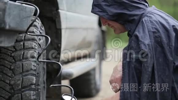 穿雨衣的男子在路边驾驶越野车视频