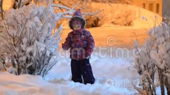 快乐美丽的小女孩在冬天扔雪，夜晚照明