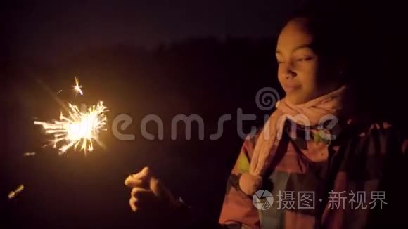 快乐的黑人女孩用火花在空中画线条