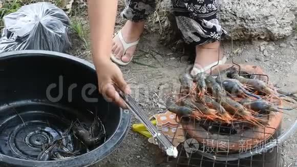 泰国妇女在户外烹饪烤虾或大虾