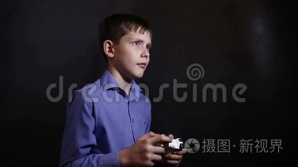 穿着蓝色衬衫的少年玩电子游戏视频