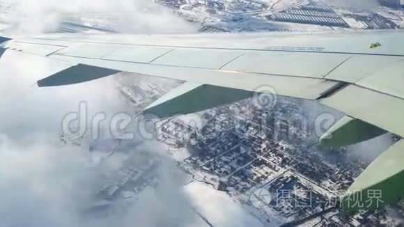 在冬季地表上空飞行。 从飞机窗口观看。 在莫斯科上空盘旋，穿过云层