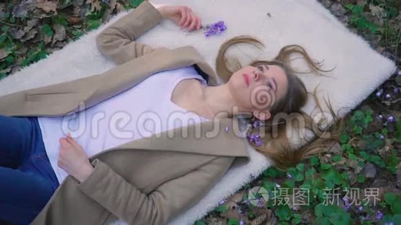 美丽的少女躺在森林的花朵里视频